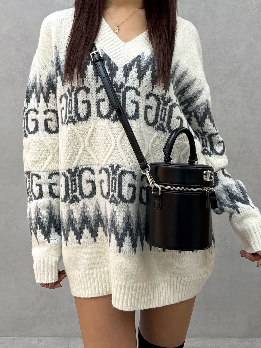 ホワイト系のニット/セーター、ブラック系のハンドバッグ、ブラック系のブーツを着用したレディースの冬コーディネートの5枚目の写真