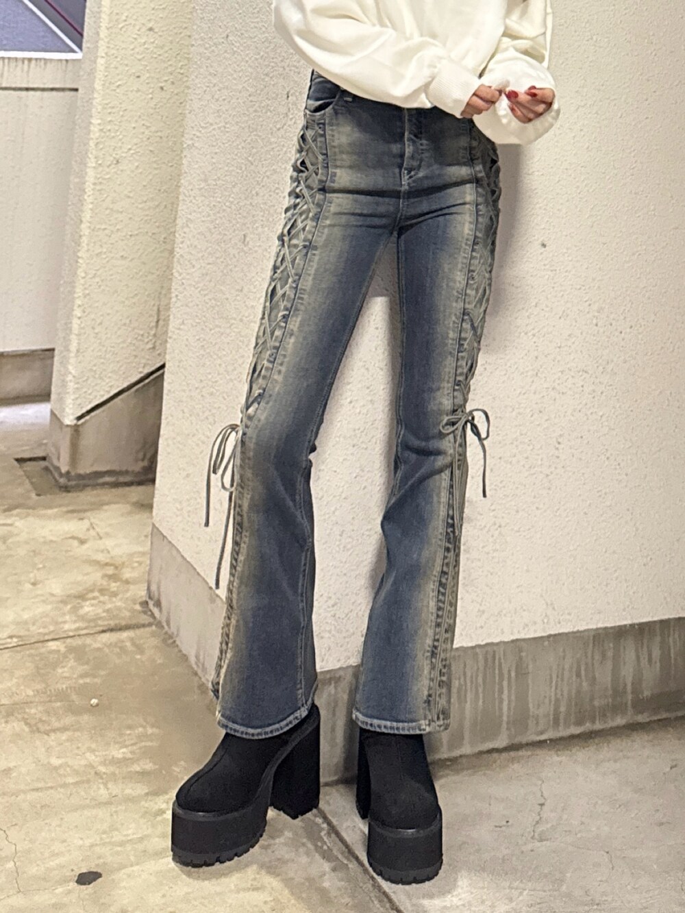 ホワイト系のニット/セーター、ブルー系のデニムパンツ、ブラック系のブーツを着用したレディースの秋コーディネートの6枚目の写真