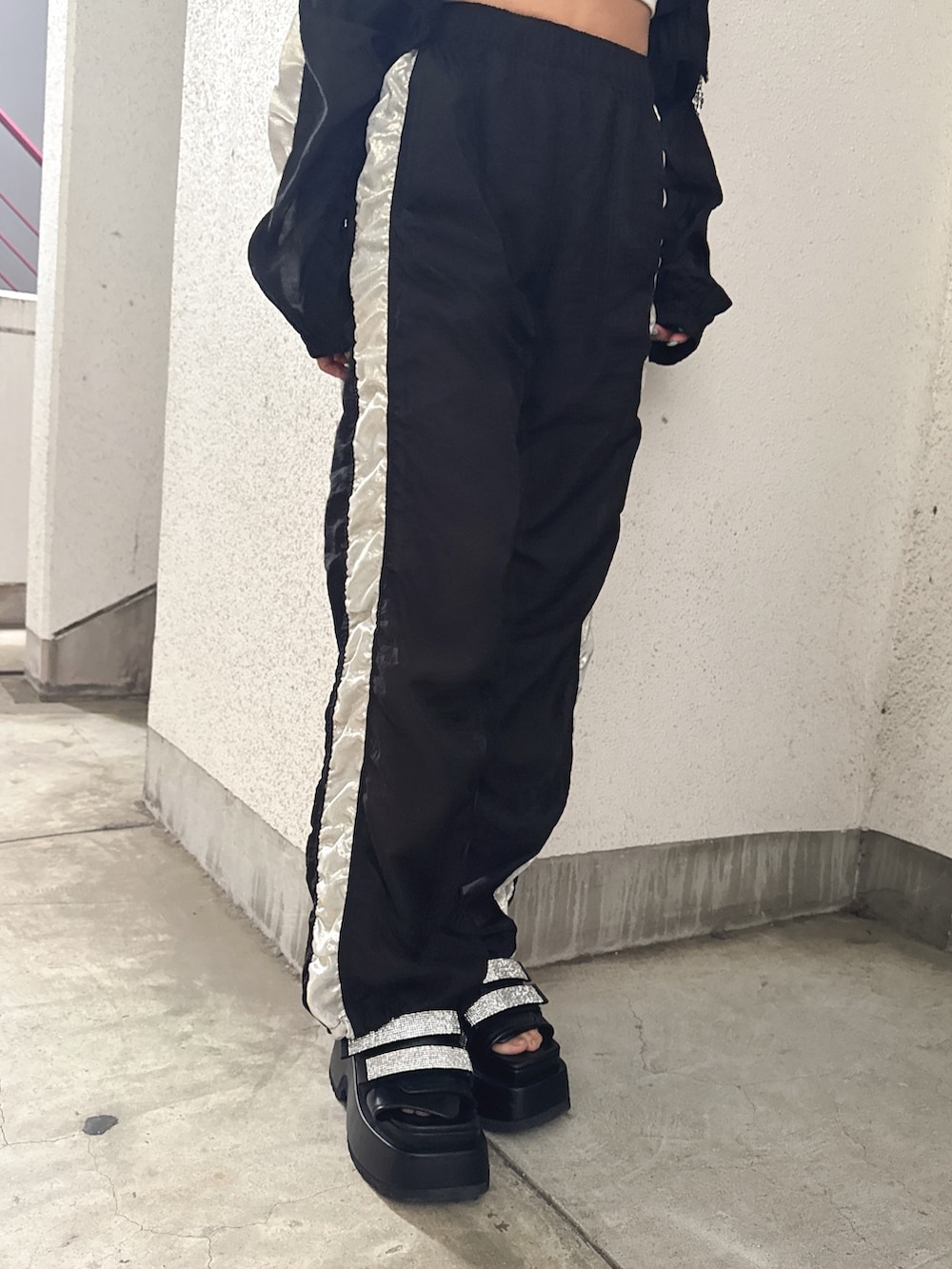 ホワイト系のチューブトップ、ブラック系のブルゾン、ブラック系のその他パンツを着用したレディースの春コーディネートの6枚目の写真