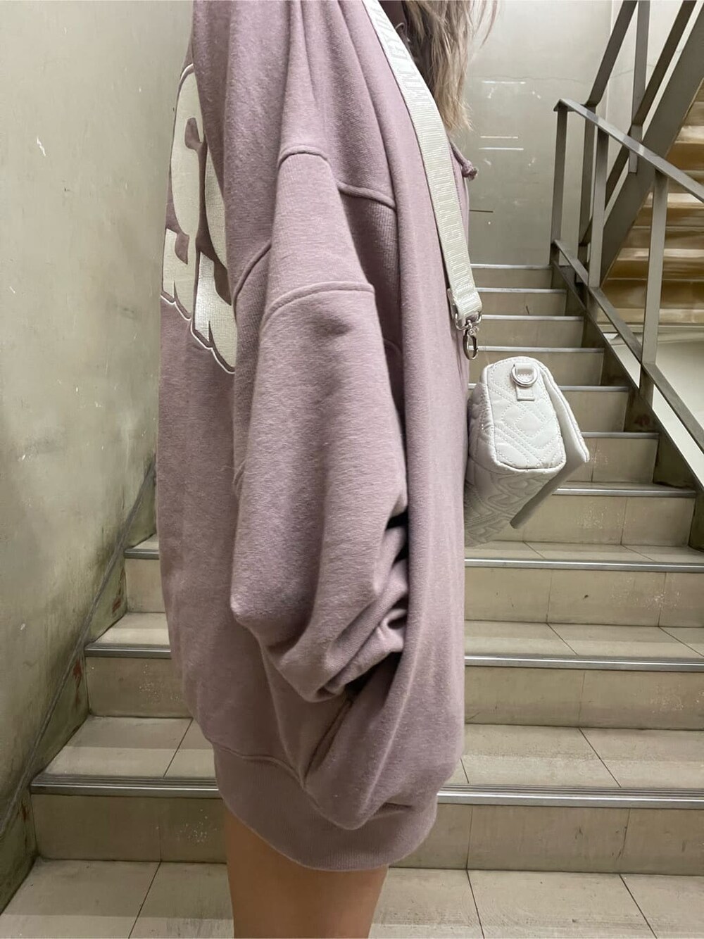 ブラック系のブーツ、ホワイト系のショルダーバッグ、ピンク系のパーカーを着用したレディースの秋コーディネートの6枚目の写真