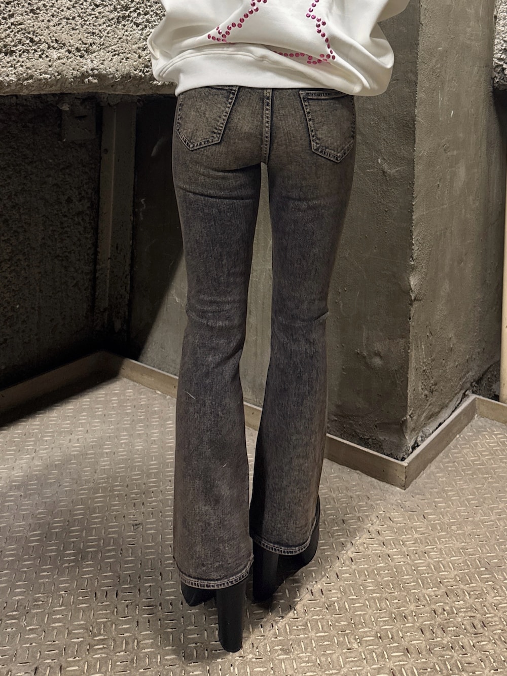 ホワイト系のスウェット、ブルー系のデニムパンツ、ブラック系のブーツを着用したレディースの冬コーディネートの9枚目の写真