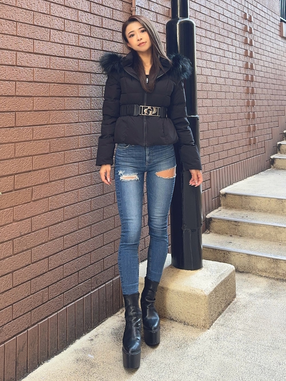 ブラック系のダウンジャケット/コート、ブラック系のニット/セーター、ブルー系のデニムパンツを着用したレディースの秋コーディネートの2枚目の写真