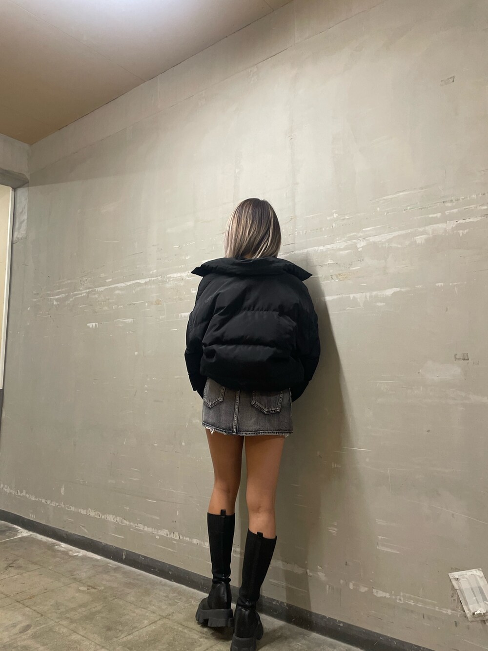 ブラック系のダウンジャケット/コート、ブラック系のニット/セーター、ブラック系のデニムパンツを着用したレディースの秋コーディネートの4枚目の写真