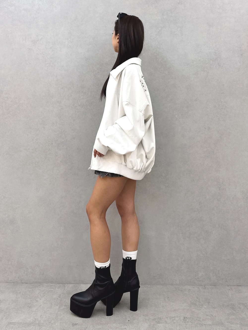 ブルー系のデニムスカート、ブラック系のブーツ、ブラック系のニット/セーターを着用したレディースの春コーディネートの3枚目の写真