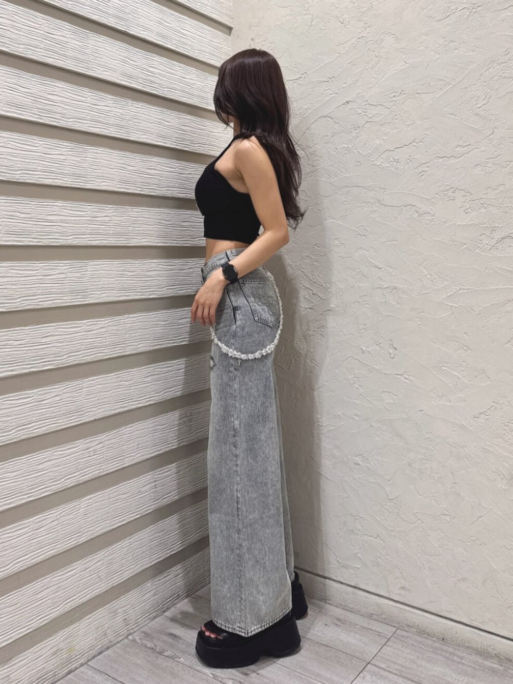 ブラック系のサンダル、ブルー系のデニムパンツ、ブラック系のチューブトップを着用したレディースの夏コーディネートの2枚目の写真