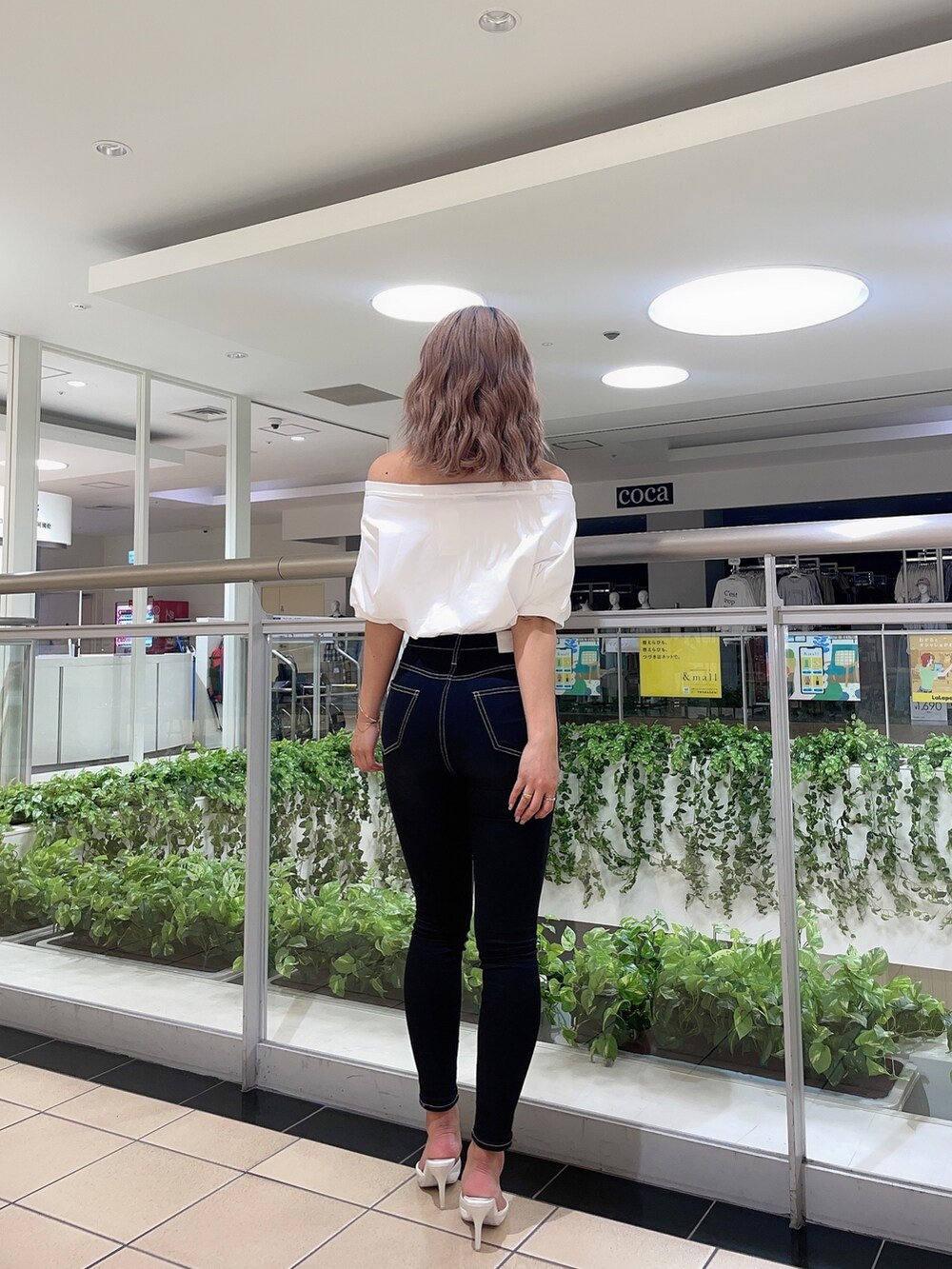 ホワイト系のTシャツ/カットソー、ブラック系のデニムパンツ、ホワイト系のパンプスを着用したレディースの春コーディネートの3枚目の写真