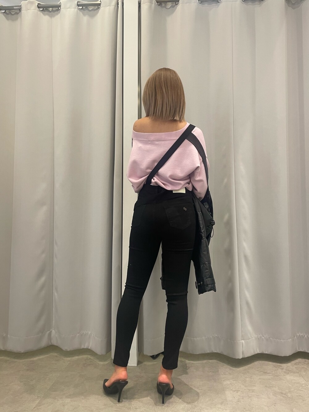 ブラック系のサロペット/オーバーオール、ピンク系のニット/セーター、ブラック系のダウンジャケット/コートを着用したレディースの冬コーディネートの7枚目の写真