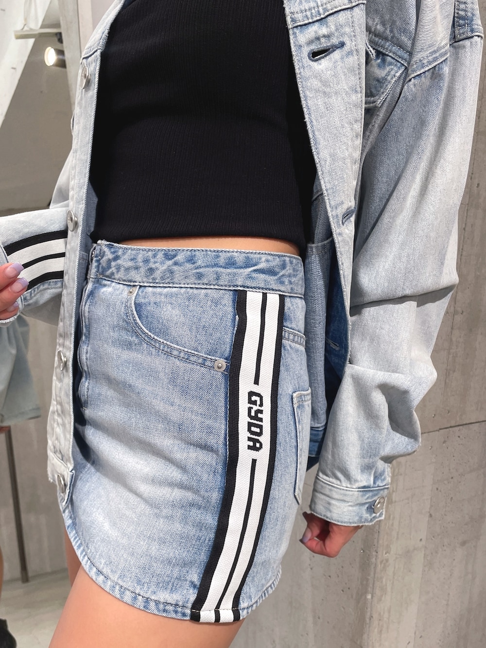 ブルー系のデニムスカート、ブラック系のブーツ、ブラック系のTシャツ/カットソーを着用したレディースの春コーディネートの8枚目の写真