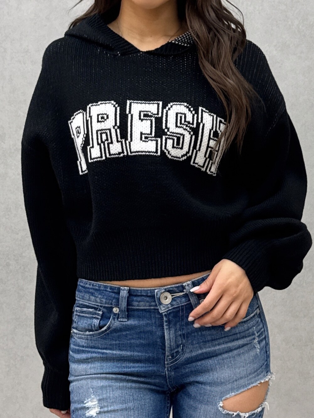 ブラック系のニット/セーター、ブルー系のデニムパンツ、ホワイト系のパンプスを着用したレディースの冬コーディネートの5枚目の写真