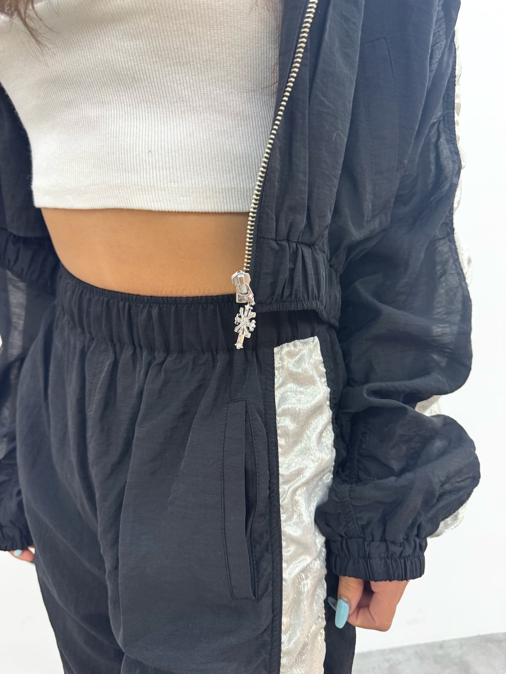 ホワイト系のチューブトップ、ブラック系のブルゾン、ブラック系のその他パンツを着用したレディースの春コーディネートの8枚目の写真