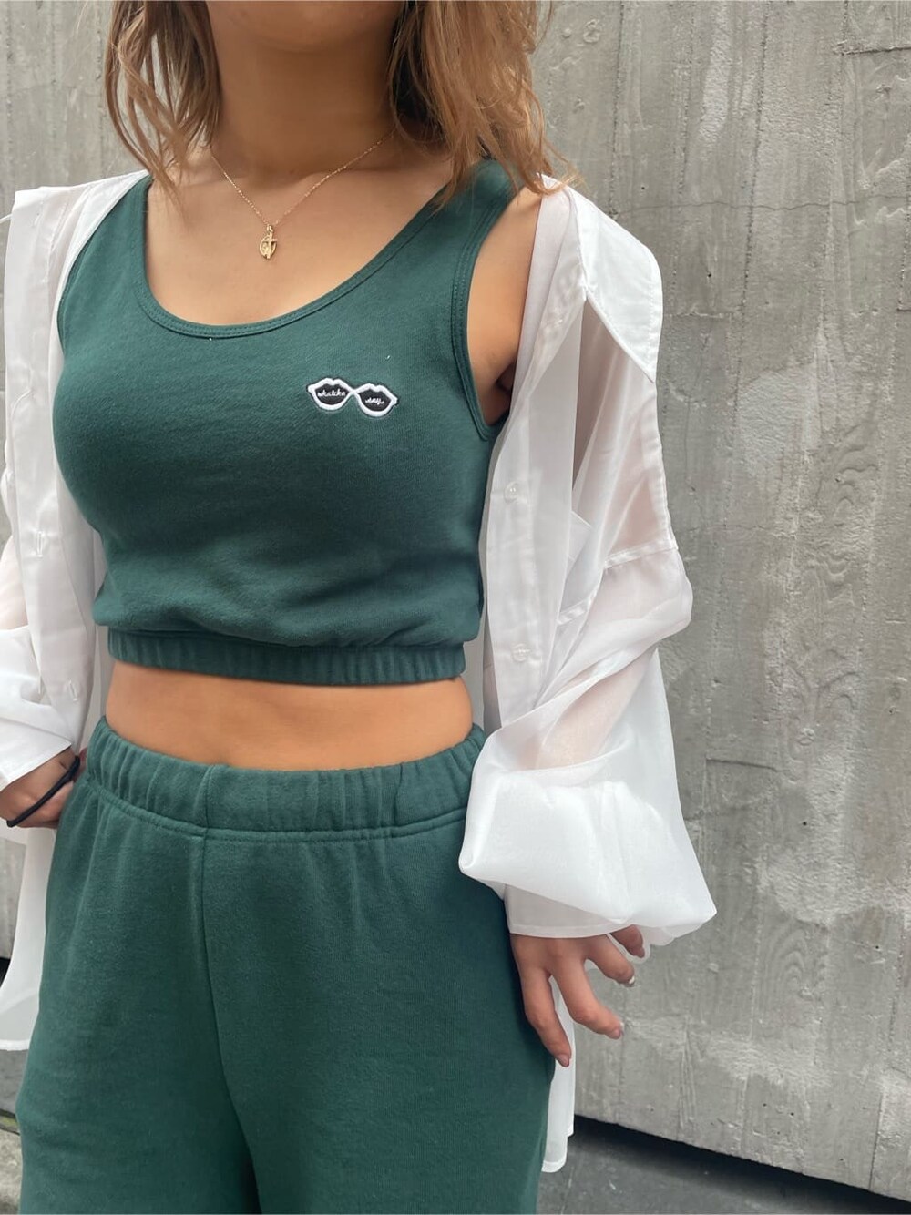 ブラック系のショルダーバッグ、ホワイト系のシャツ/ブラウス、グリーン系のスウェットパンツを着用したレディースの春コーディネートの7枚目の写真