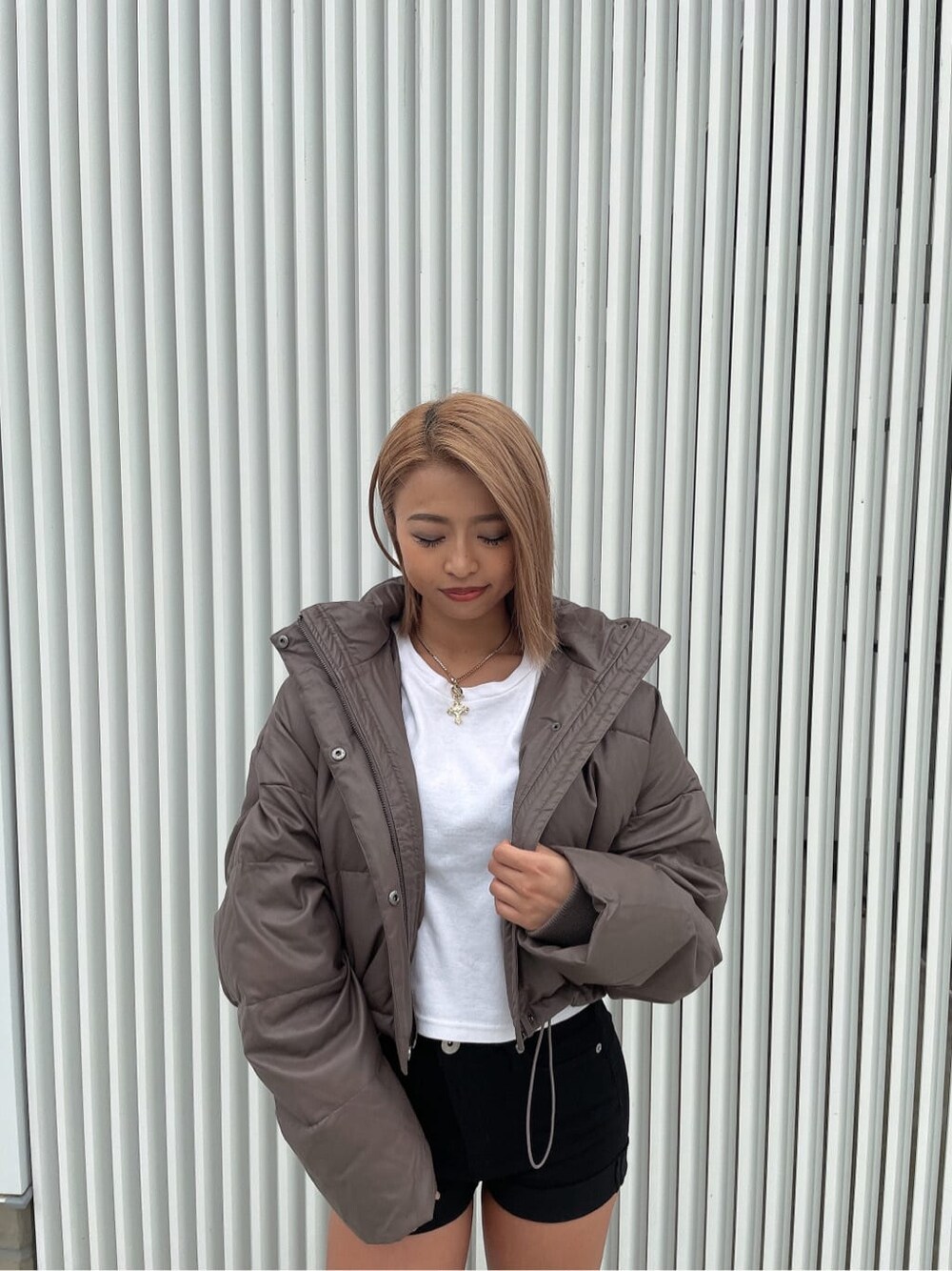 ベージュ系のダウンジャケット/コート、ブラック系のデニムパンツ、ブラック系のブーツを着用したレディースの秋コーディネートの6枚目の写真