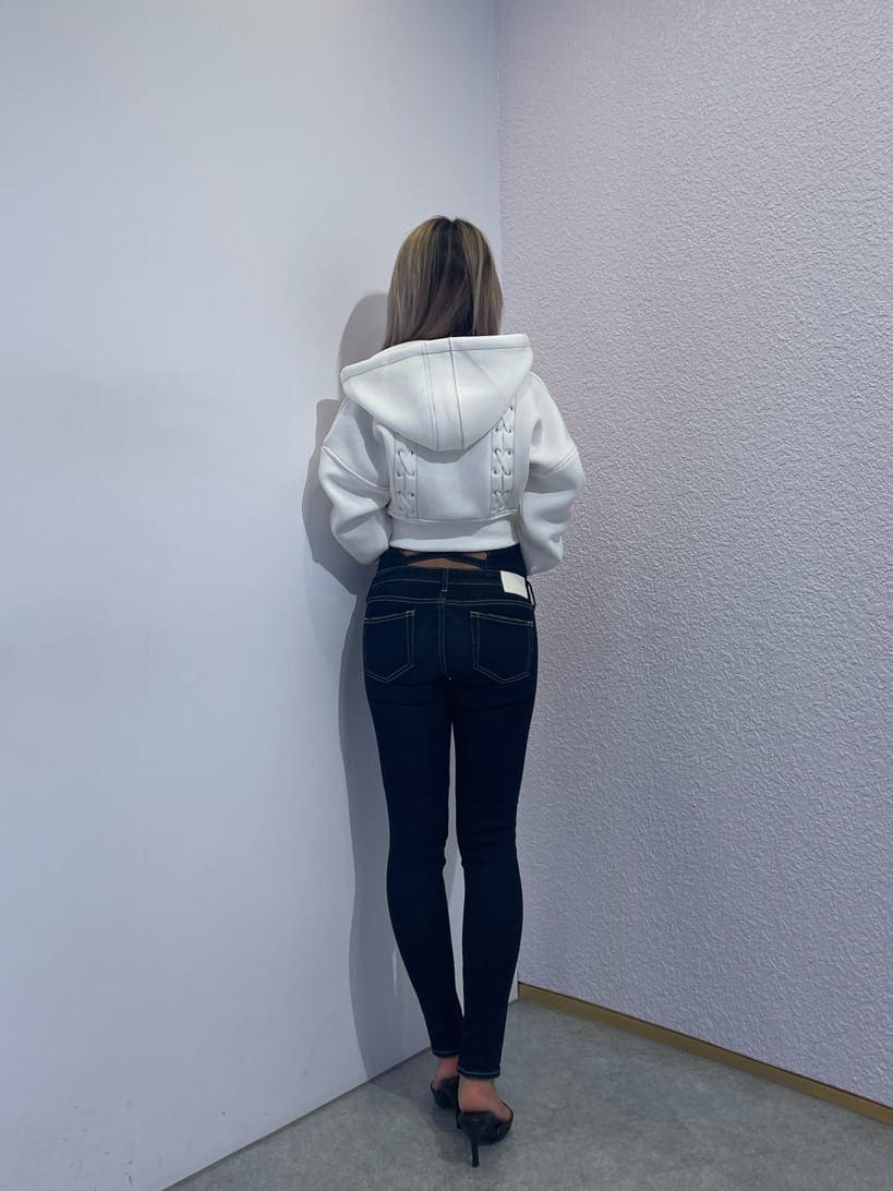 ブルー系のデニムパンツ、ホワイト系のパーカー、ブラック系のパンプスを着用したレディースの秋コーディネートの3枚目の写真