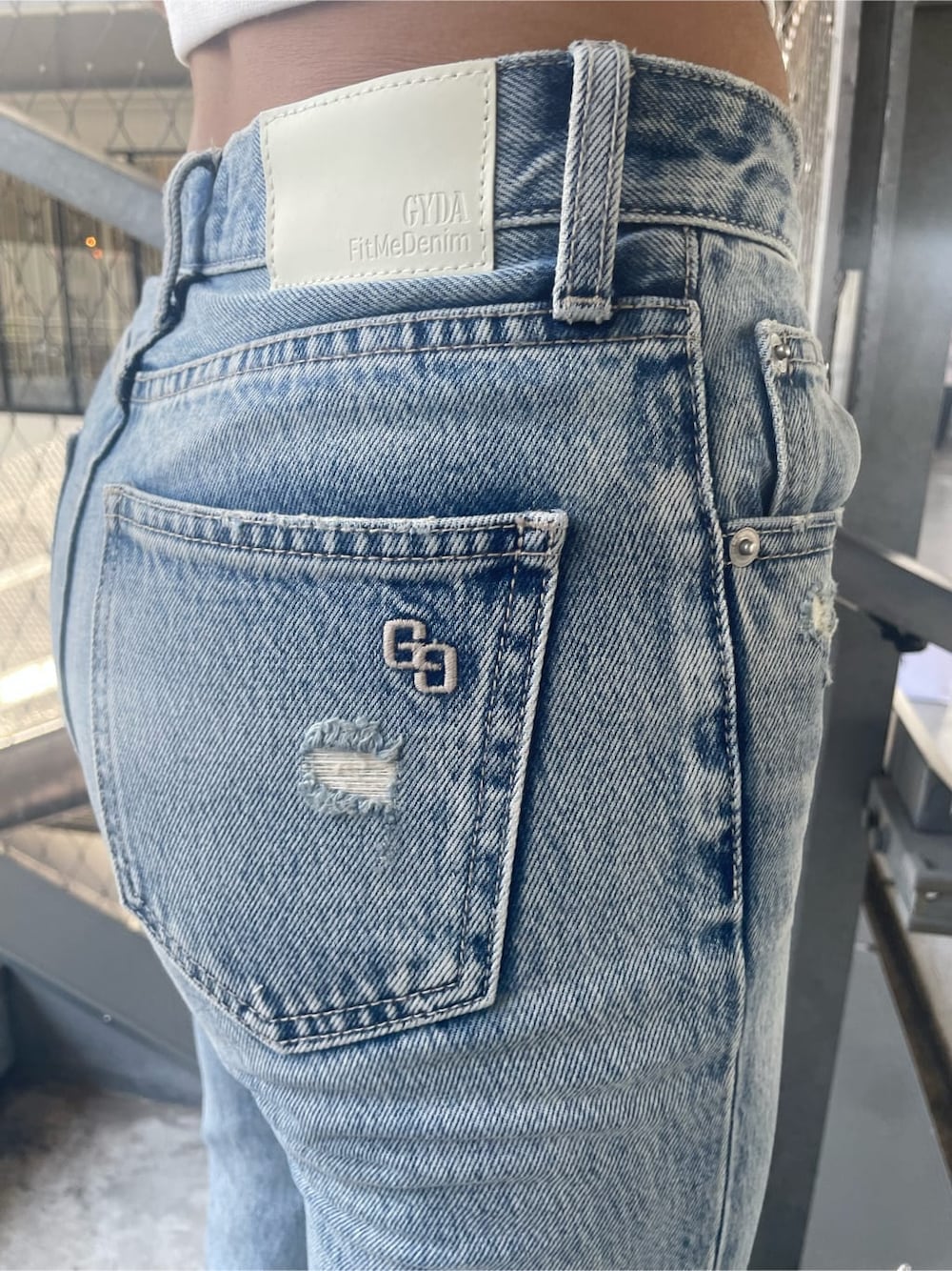 ブルー系のデニムパンツ、ホワイト系のタンクトップを着用したレディースの夏コーディネートの7枚目の写真