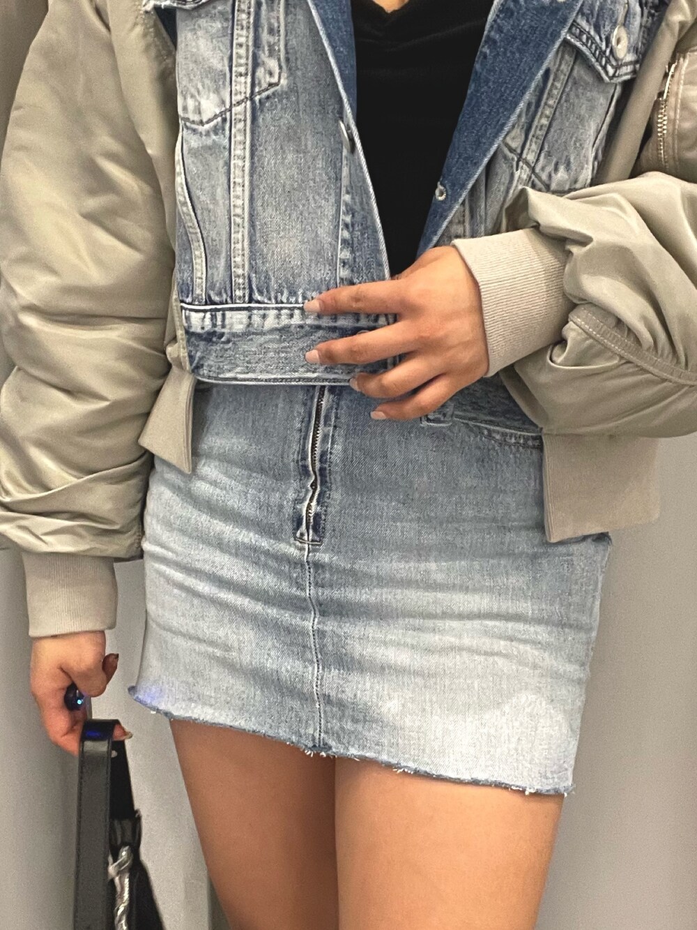 ブルー系のデニムジャケット、ブルー系のデニムスカート、ブラック系のチューブトップを着用したレディースの冬コーディネートの8枚目の写真