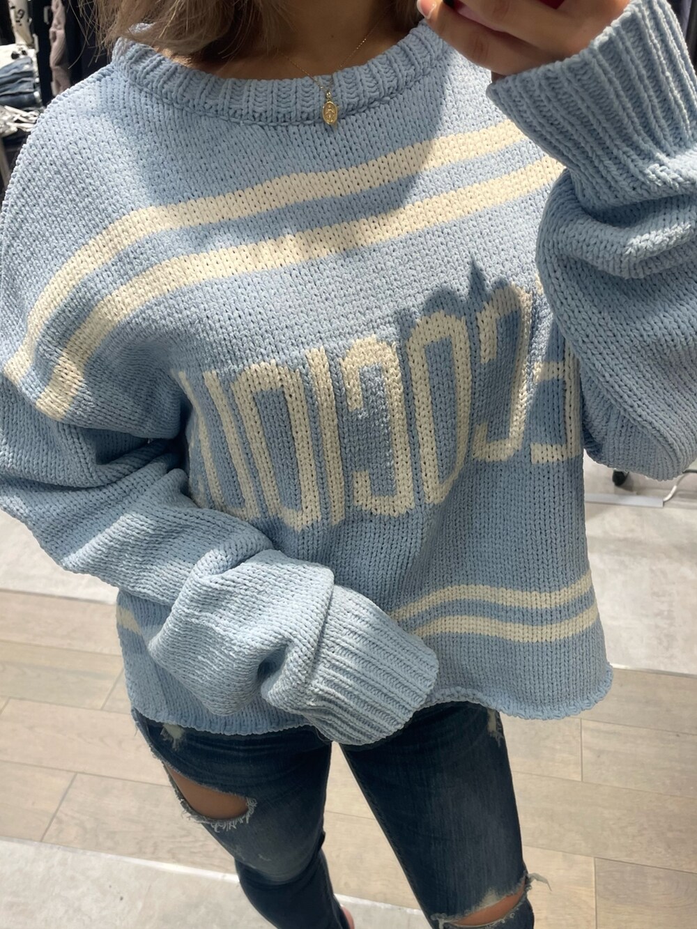 ブルー系のニット/セーター、ブルー系のデニムパンツ、ホワイト系のパンプスを着用したレディースの冬コーディネートの4枚目の写真