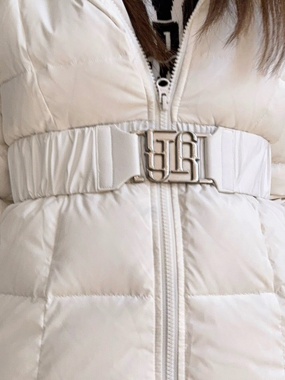 ブラック系のブーツ、ホワイト系のダウンジャケット/コート、ホワイト系のニット/セーターを着用したレディースの秋コーディネートの7枚目の写真