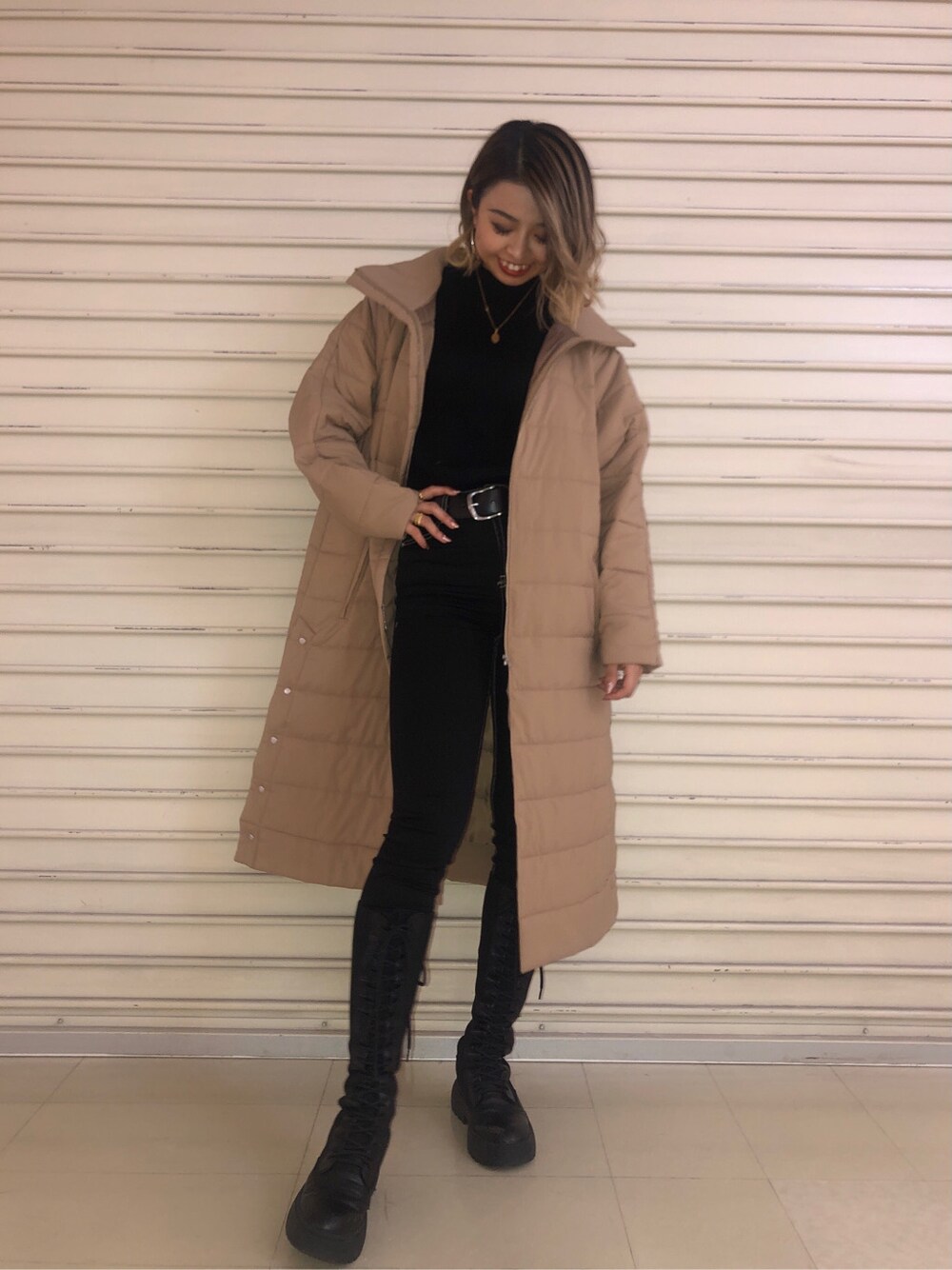 ブラック系のニット/セーター、ベージュ系のダウンジャケット/コート、ブラック系のデニムパンツを着用したレディースの冬コーディネートの2枚目の写真