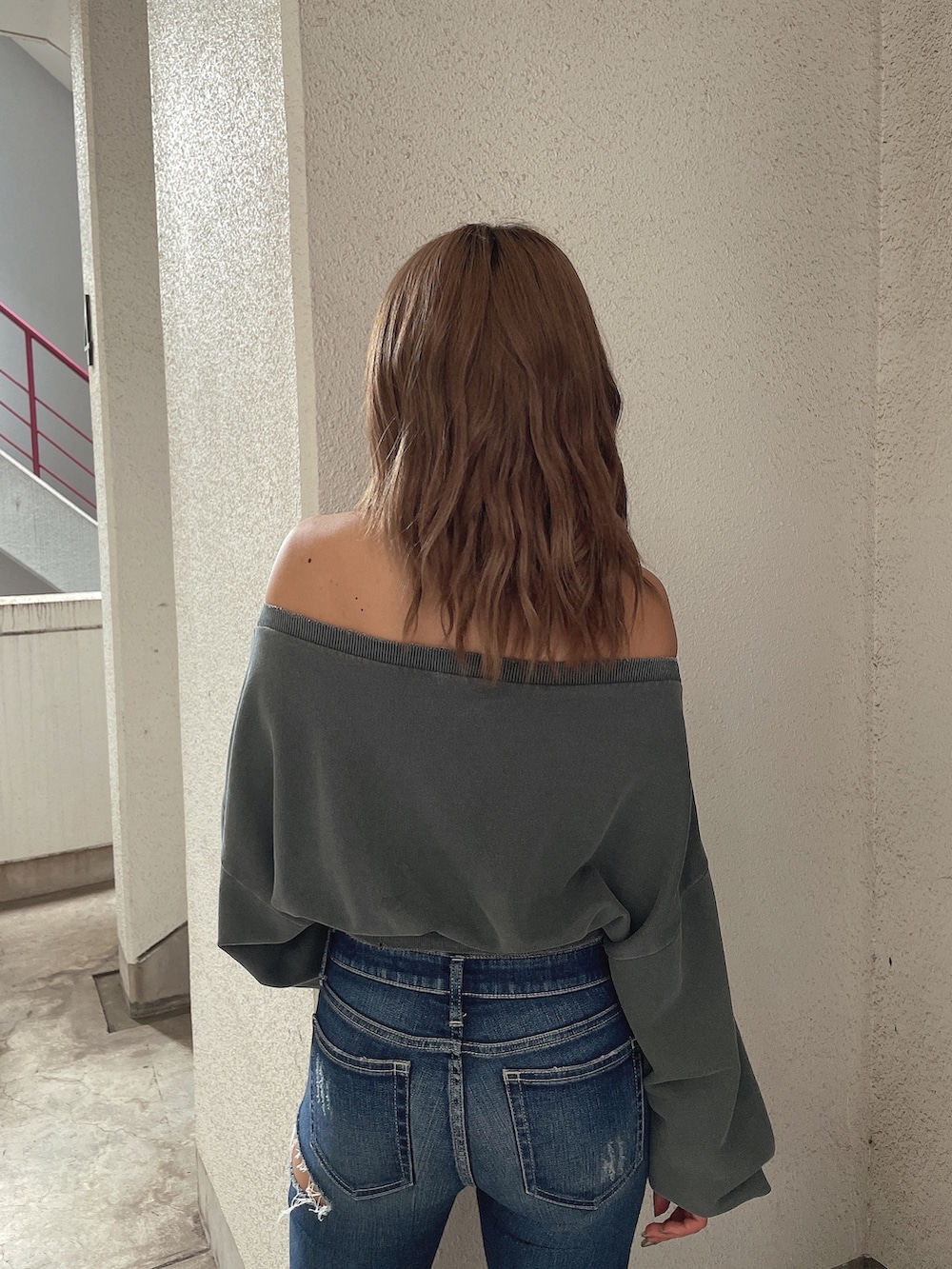 グレー系のスウェット、ブルー系のデニムパンツ、ブラック系のパンプスを着用したレディースの夏コーディネートの5枚目の写真