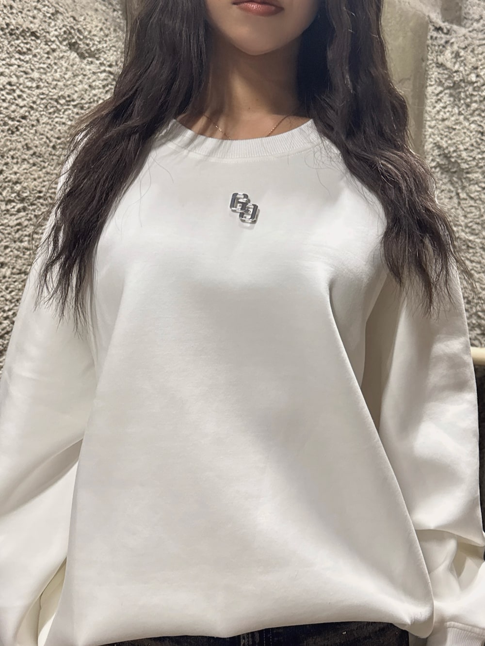 ホワイト系のスウェット、ブルー系のデニムパンツ、ブラック系のブーツを着用したレディースの冬コーディネートの6枚目の写真