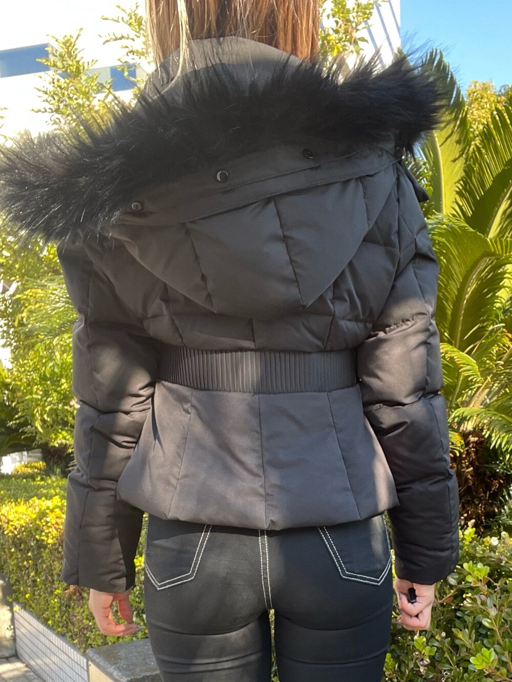 ブラック系のデニムパンツ、ブラック系のニット/セーター、ブラック系のその他アウターを着用したレディースの冬コーディネートの5枚目の写真