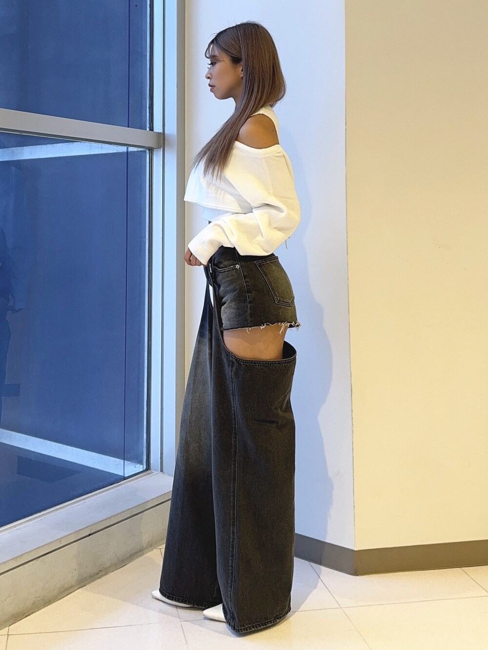 ホワイト系のアンサンブル、ブラック系のデニムパンツ、ホワイト系のパンプスを着用したレディースの秋コーディネートの3枚目の写真