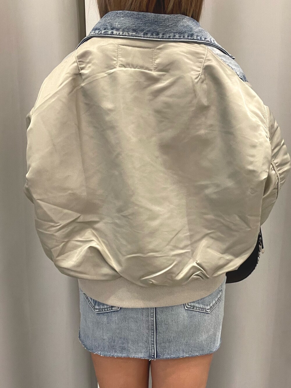 ブルー系のデニムジャケット、ブルー系のデニムスカート、ブラック系のチューブトップを着用したレディースの冬コーディネートの6枚目の写真