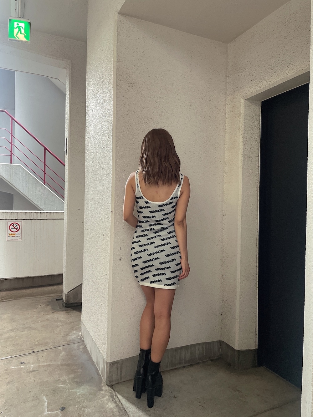 ホワイト系のワンピース、ブラック系のブーツを着用したレディースの夏コーディネートの2枚目の写真