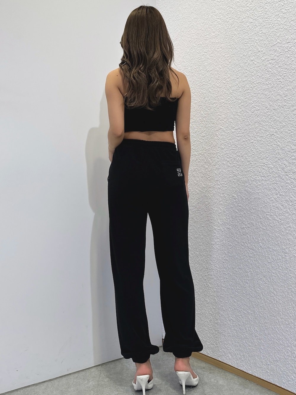 ブラック系のチューブトップ、ブラック系のその他パンツ、ホワイト系のパンプスを着用したレディースの春コーディネートの4枚目の写真