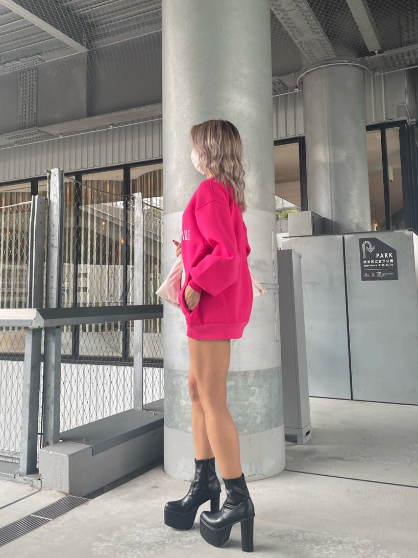 ブルー系のデニムパンツ、ピンク系のスウェット、ブラック系のブーツを着用したレディースの夏コーディネートの6枚目の写真