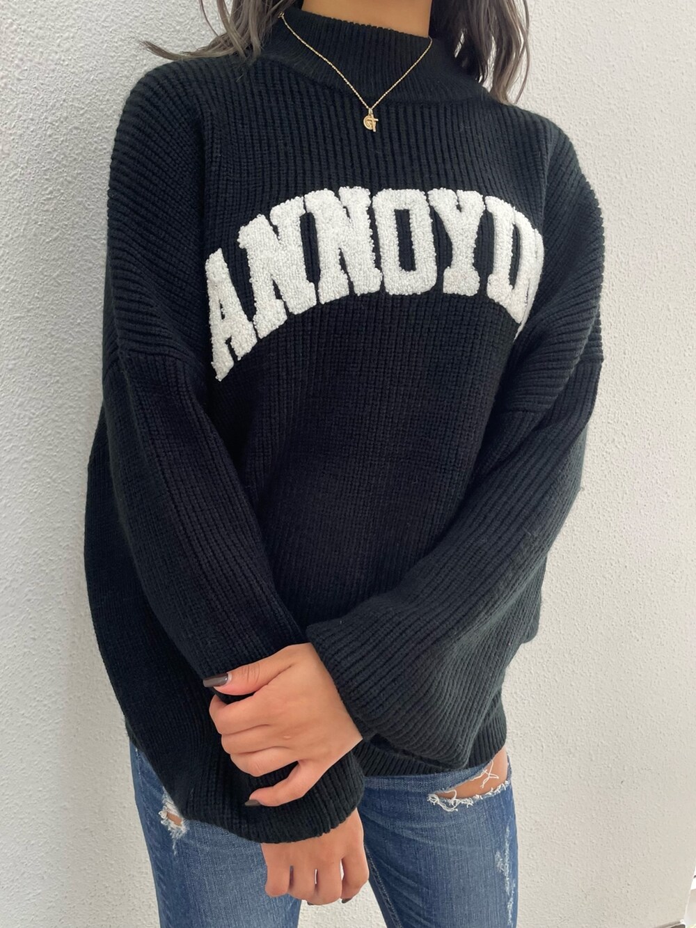 ブラック系のニット/セーター、ブルー系のデニムパンツ、ブラック系のパンプスを着用したレディースの秋コーディネートの6枚目の写真