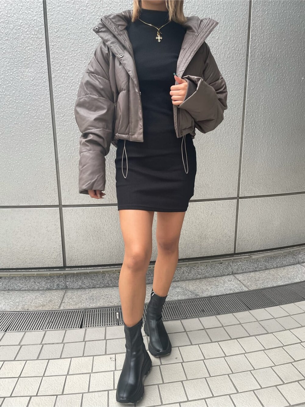 ベージュ系のダウンジャケット/コート、ブラック系のブーツ、ブラック系のワンピースを着用したレディースの秋コーディネートの4枚目の写真