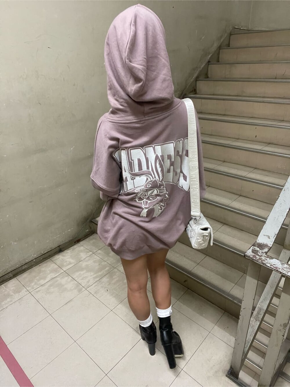 ブラック系のブーツ、ホワイト系のショルダーバッグ、ピンク系のパーカーを着用したレディースの秋コーディネートの7枚目の写真