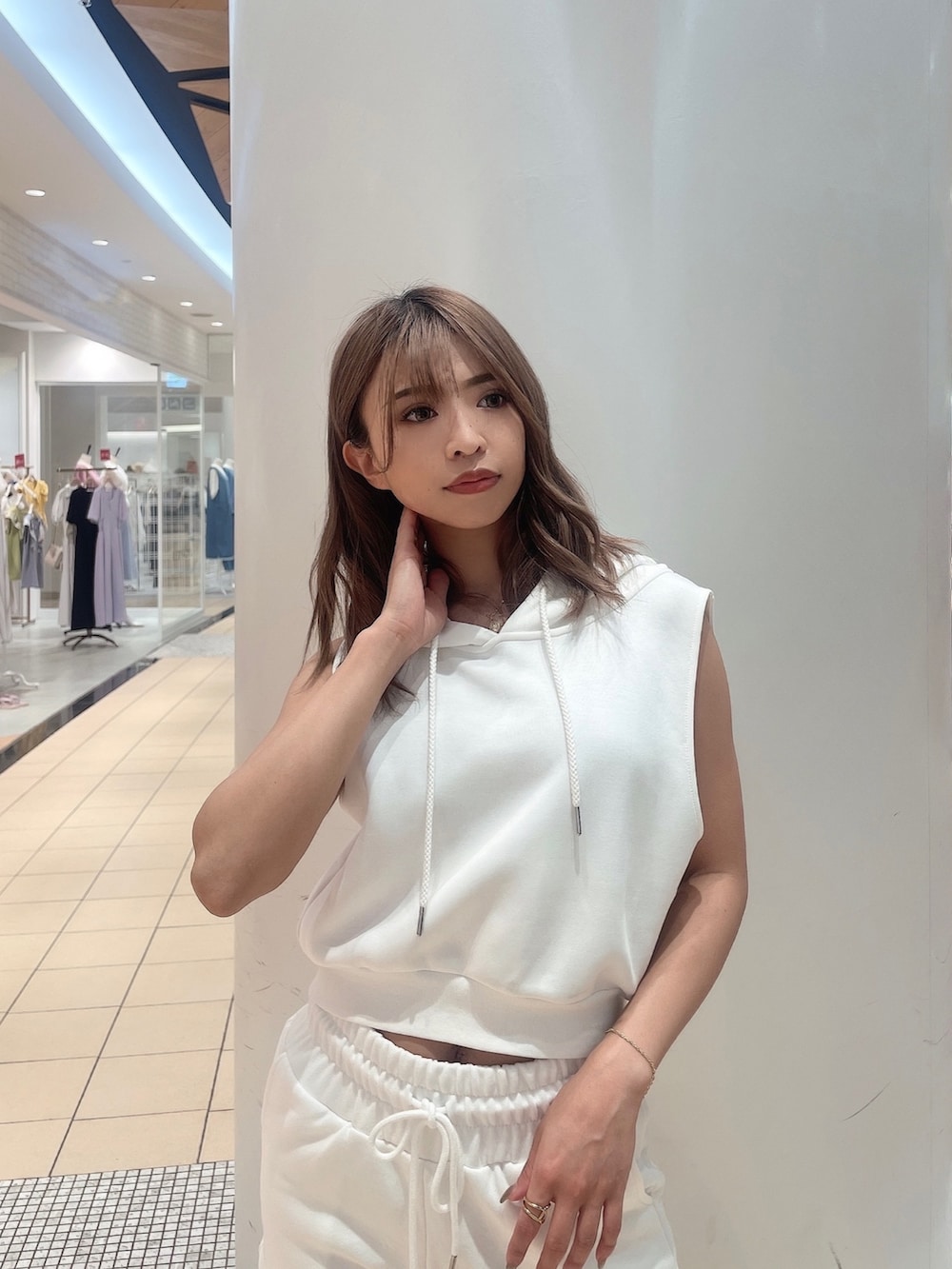 ホワイト系のパーカー、ホワイト系のスウェットパンツ、ブラック系のスニーカーを着用したレディースの夏コーディネートの5枚目の写真