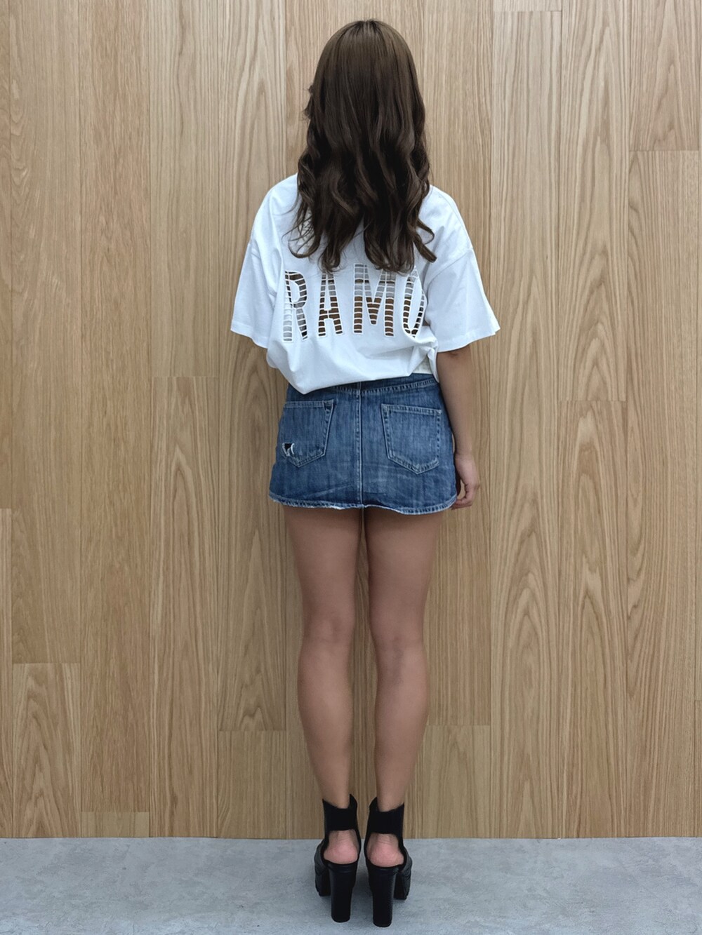 ホワイト系のTシャツ/カットソー、ブルー系のデニムスカート、ブラック系のブーツを着用したレディースの春コーディネートの2枚目の写真