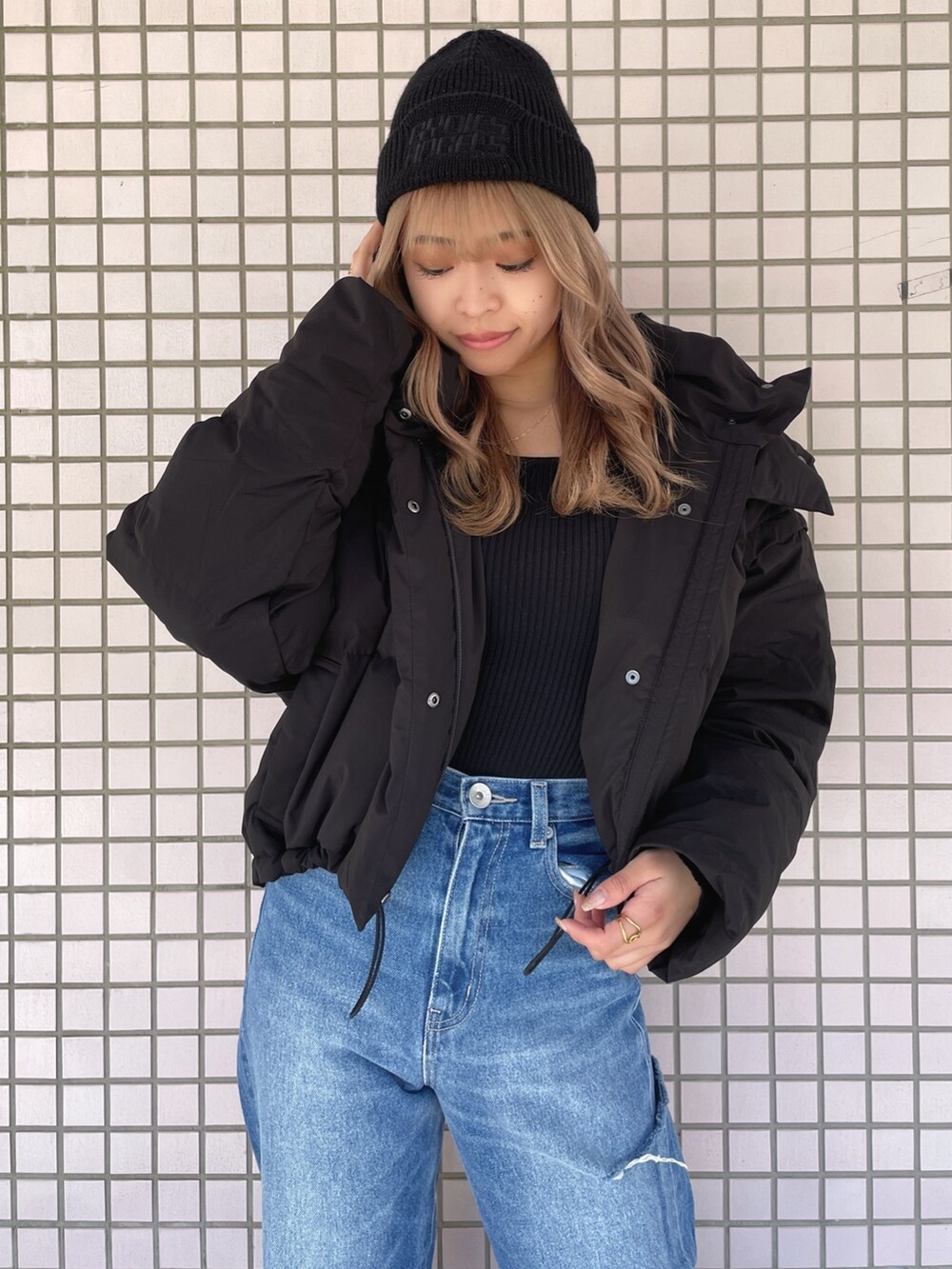 ホワイト系のスニーカー、ブルー系のデニムパンツ、ブラック系のニット/セーターを着用したレディースの冬コーディネートの5枚目の写真