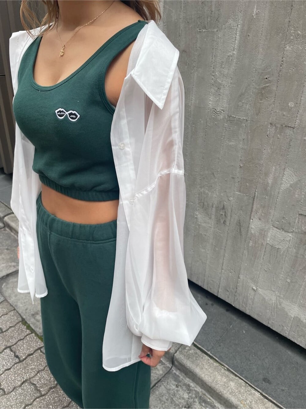 ブラック系のショルダーバッグ、ホワイト系のシャツ/ブラウス、グリーン系のスウェットパンツを着用したレディースの春コーディネートの6枚目の写真