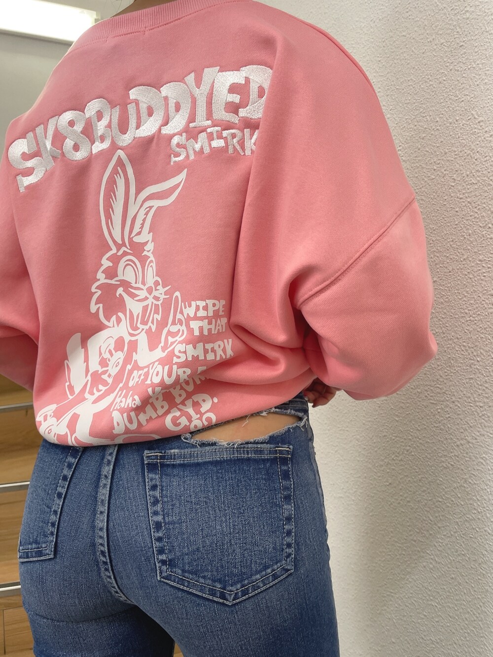 ピンク系のスウェット、ブルー系のデニムパンツ、ブラック系のパンプスを着用したレディースの春コーディネートの6枚目の写真