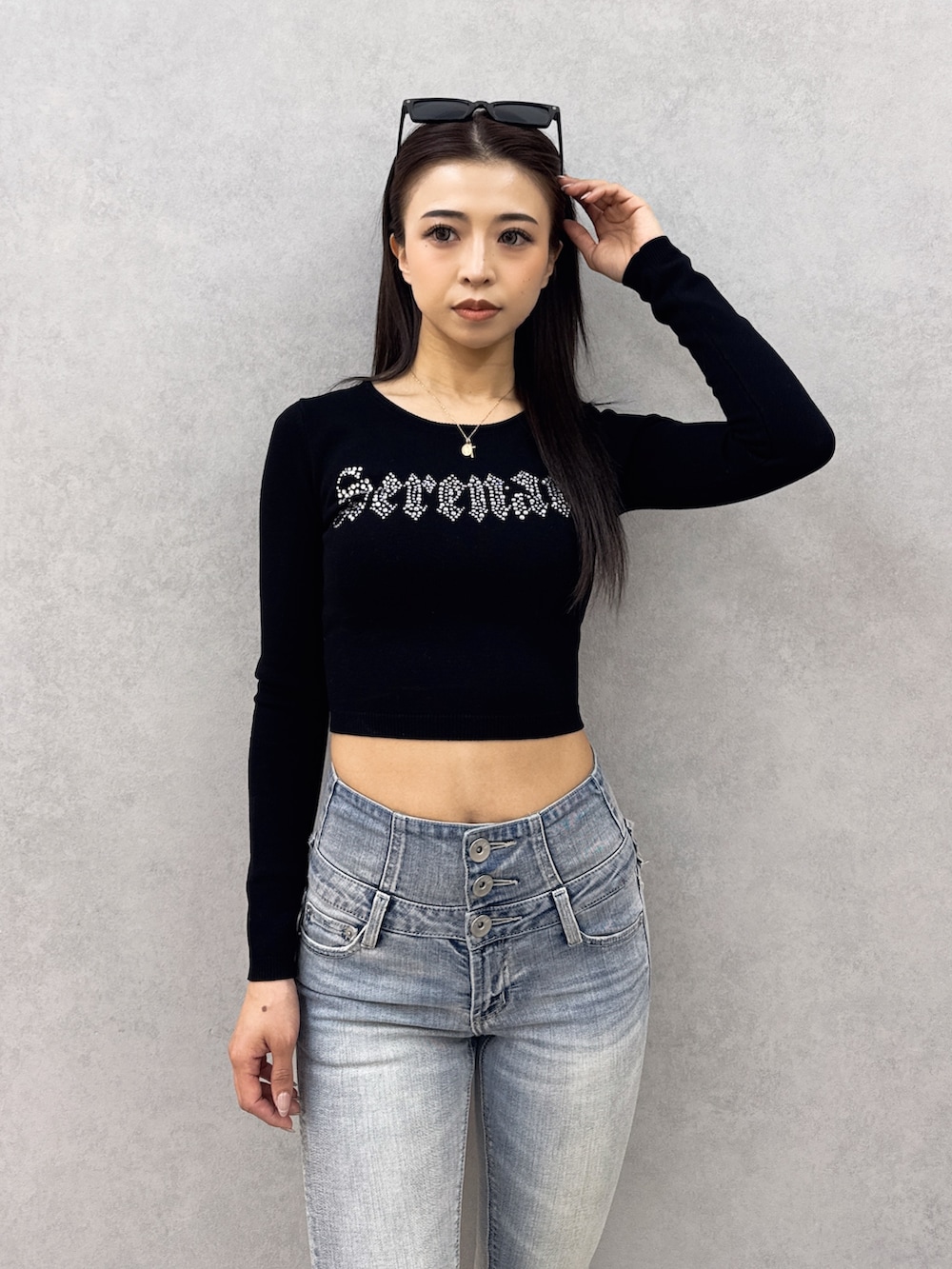 ブラック系のニット/セーター、ブルー系のデニムパンツ、ホワイト系のパンプスを着用したレディースの春コーディネートの5枚目の写真