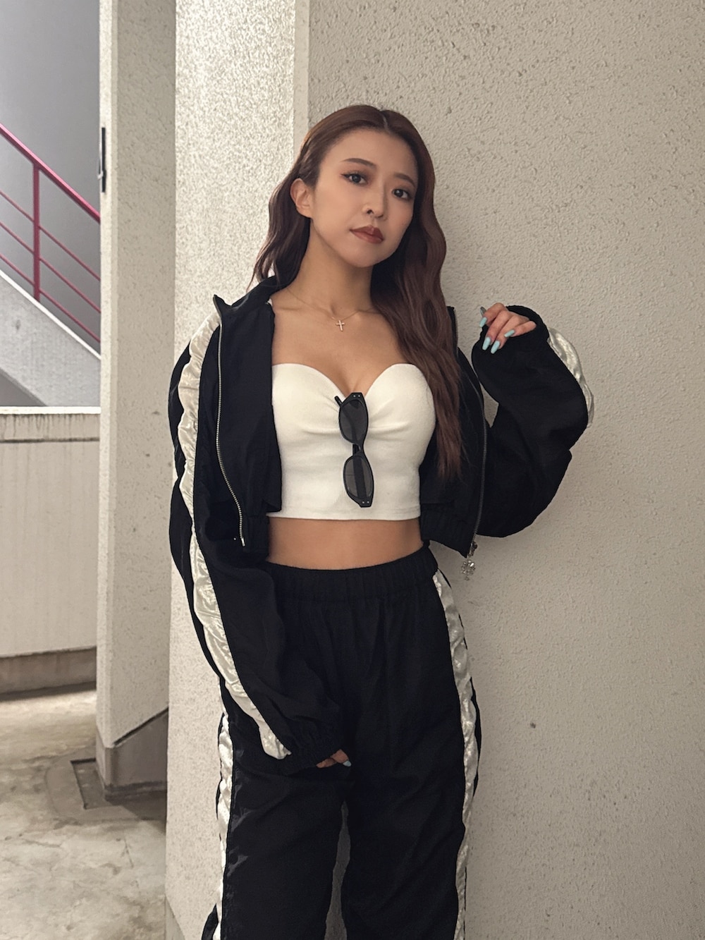 ホワイト系のチューブトップ、ブラック系のブルゾン、ブラック系のその他パンツを着用したレディースの春コーディネートの4枚目の写真