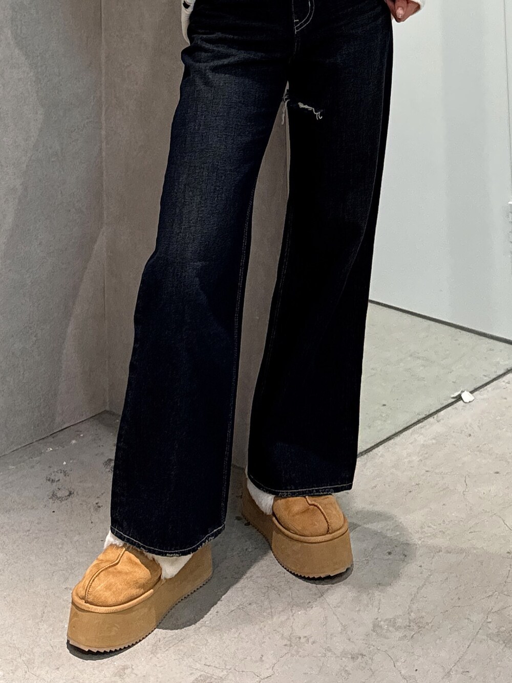 ホワイト系のニット/セーター、ブルー系のデニムパンツ、ベージュ系のスリッポンを着用したレディースの冬コーディネートの6枚目の写真