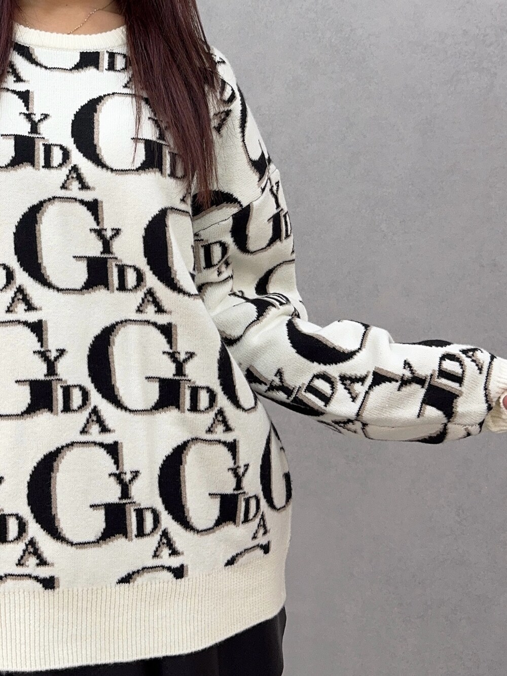 ホワイト系のニット/セーター、ブラック系のスカート、ブラック系のハンドバッグを着用したレディースの冬コーディネートの5枚目の写真