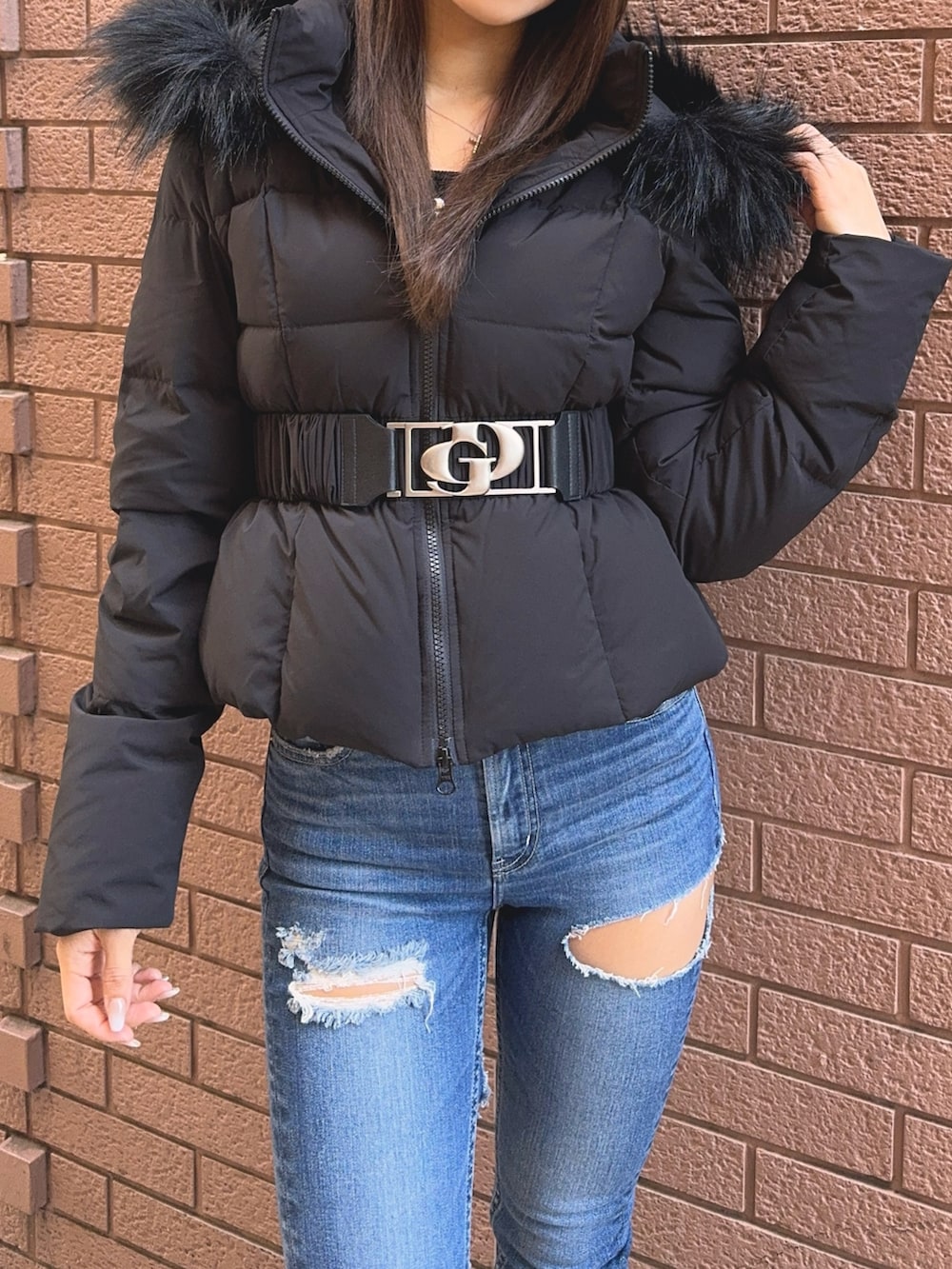 ブラック系のダウンジャケット/コート、ブラック系のニット/セーター、ブルー系のデニムパンツを着用したレディースの秋コーディネートの7枚目の写真