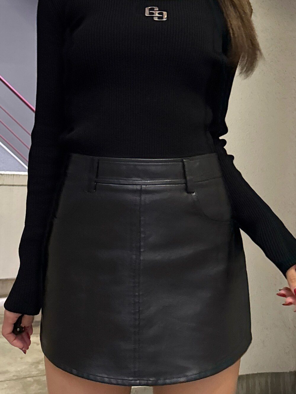 ブラック系のニット/セーター、ブラック系のスカート、ブラック系のブーツを着用したレディースの秋コーディネートの6枚目の写真