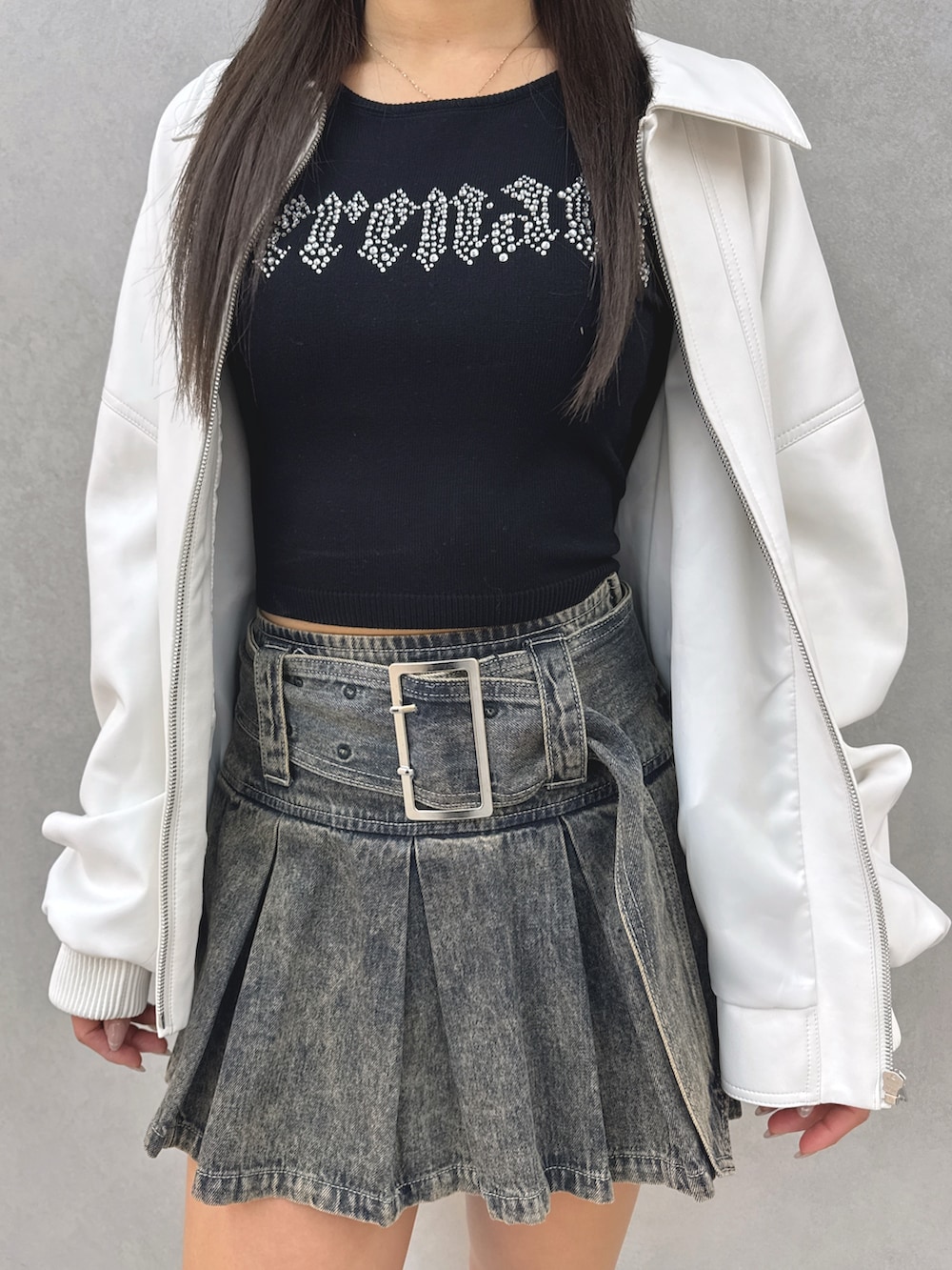 ブルー系のデニムスカート、ブラック系のブーツ、ブラック系のニット/セーターを着用したレディースの春コーディネートの6枚目の写真