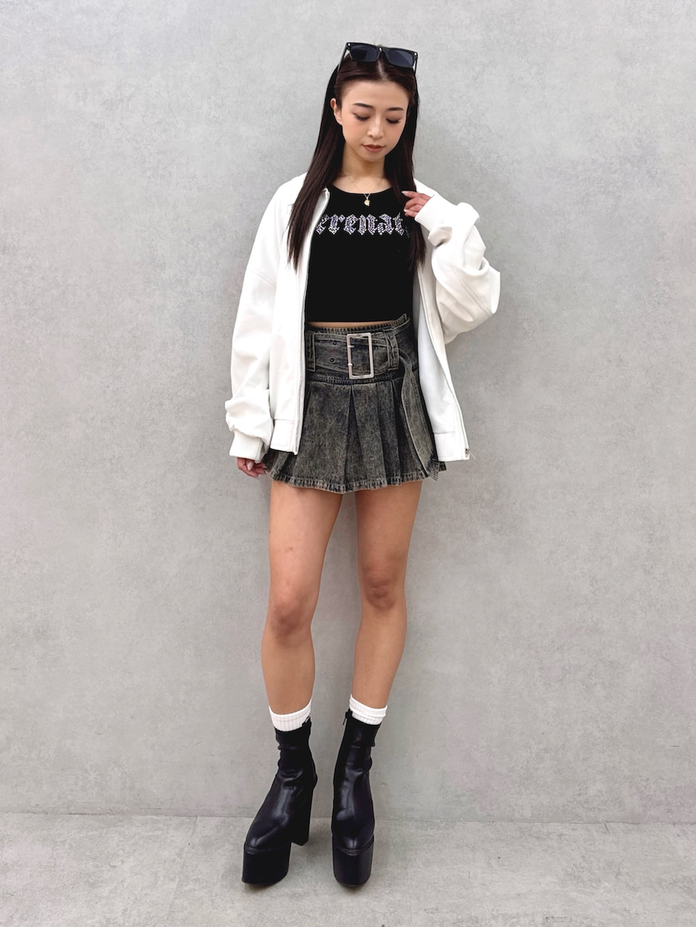 ブルー系のデニムスカート、ブラック系のブーツ、ブラック系のニット/セーターを着用したレディースの春コーディネートの2枚目の写真