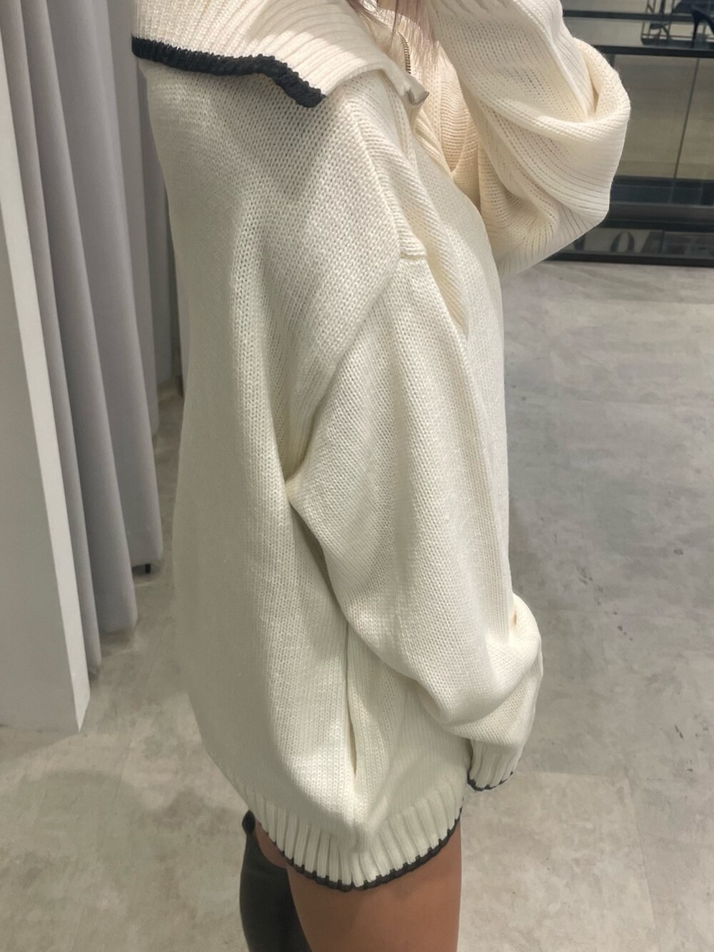 ホワイト系のニット/セーター、ブラック系のスカート、ブラック系のブーツを着用したレディースの冬コーディネートの4枚目の写真