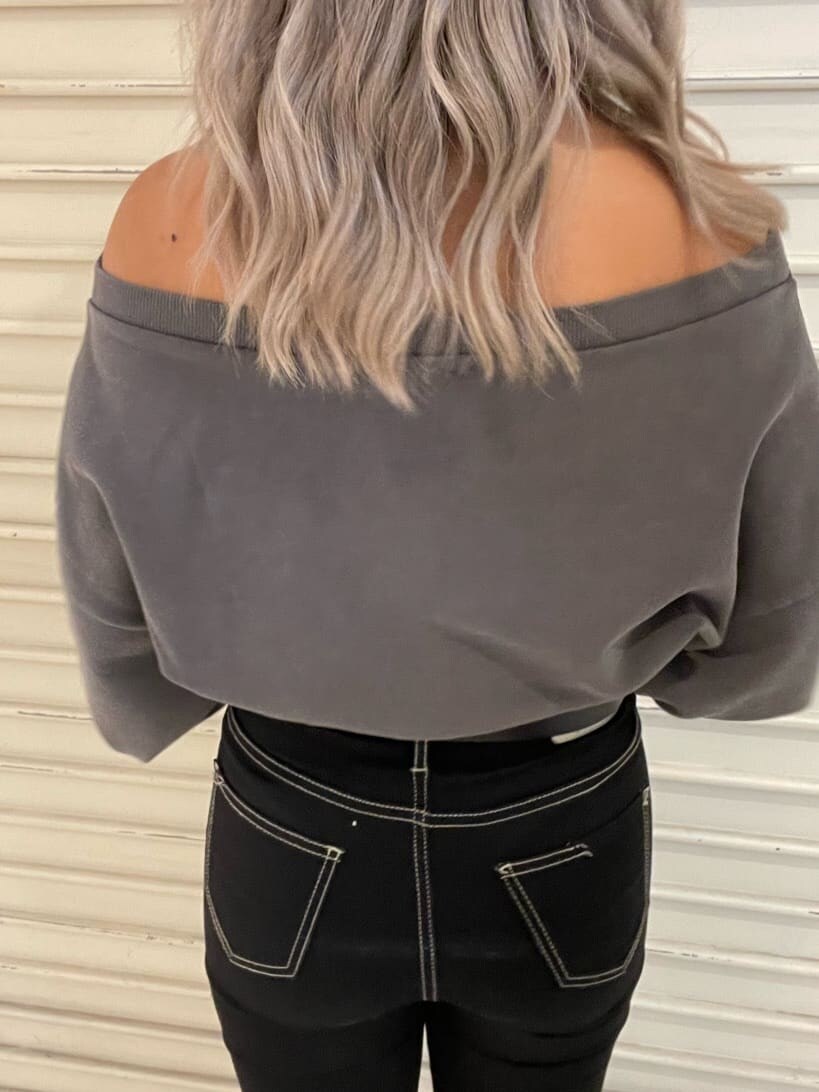 ブラック系のデニムパンツ、グレー系のスウェット、ブラック系のブーツを着用したレディースの秋コーディネートの7枚目の写真