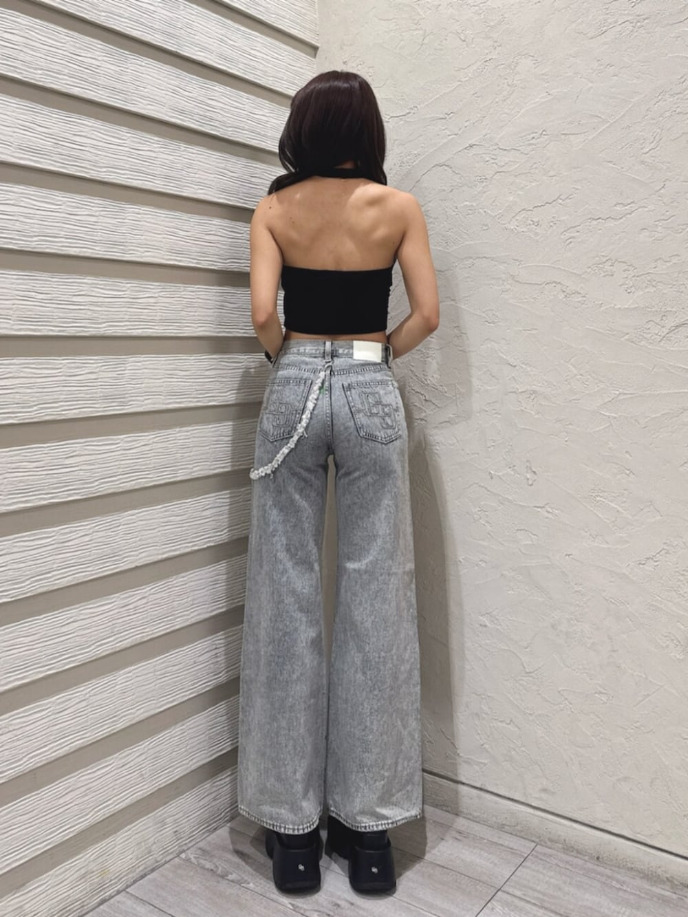 ブラック系のサンダル、ブルー系のデニムパンツ、ブラック系のチューブトップを着用したレディースの夏コーディネートの3枚目の写真