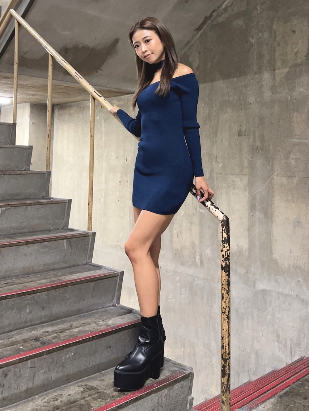 ブルー系のワンピース、ブラック系のブーツを着用したレディースの秋コーディネートの2枚目の写真